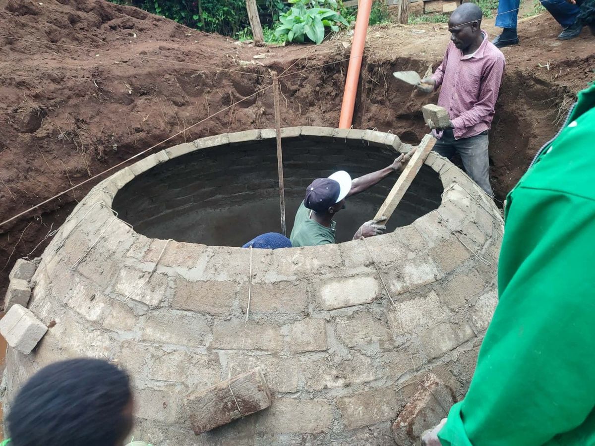 Workers building a brick digester wall